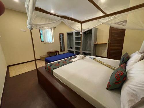 a bedroom with a large bed with a canopy at Diana Place in Paje