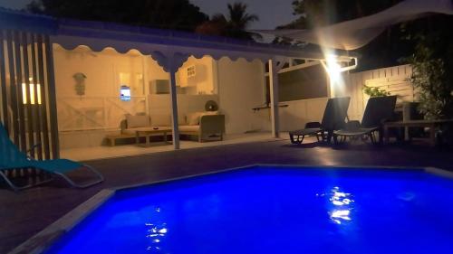 a night view of a swimming pool in a backyard at La Rose du Bresil Marie-Galante in Capesterre-de-Marie-Galante
