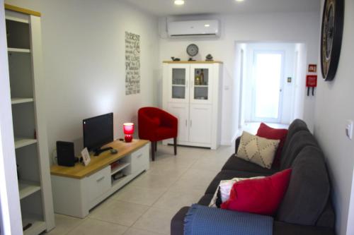 a living room with a couch and a television at Casa da Salga in Nordeste