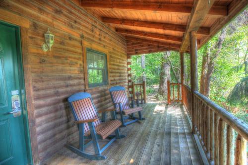 two chairs sitting on a porch of a cabin at Wild Rose Cabin by Amish Country Lodging in Millersburg