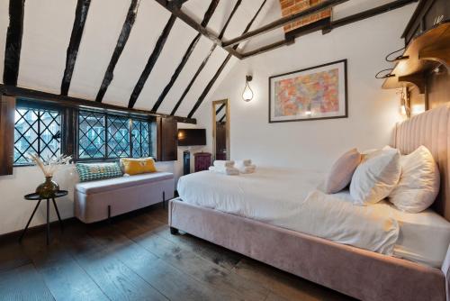 - une chambre avec un grand lit et un canapé dans l'établissement 15th century tiny character cottage-Henley centre, à Henley-on-Thames