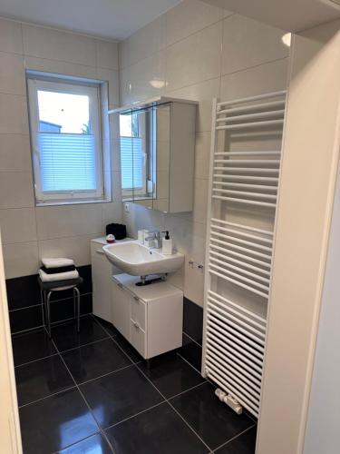 a bathroom with a sink and a mirror at Haus Hotel & Pension am Birnengarten in Magdeburg