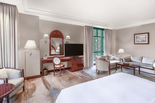 a hotel room with a bed and a television at Madinah Hilton Hotel in Al Madinah