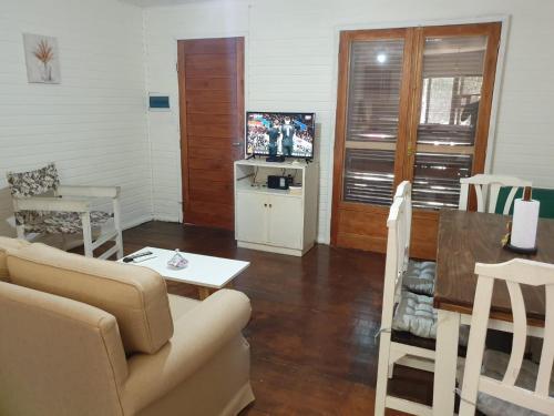 a living room with a couch and a table at Doha, paraíso mar y bosque in Rincón de los Oliveras