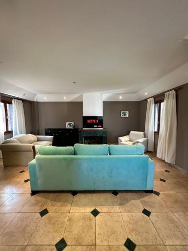una sala de estar con un sofá azul en una habitación en Super casa con vista al mar, hogar Netflix y Wifi en Mar del Plata