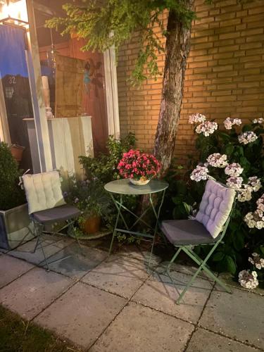 two chairs and a table with flowers on it at B&B Ereprijs in The Hague