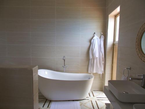 eine weiße Badewanne im Bad mit Waschbecken in der Unterkunft Jasmine Bay Hotel & Spa 