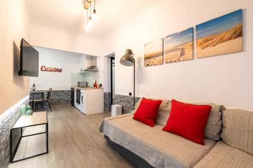 a living room with a couch and red pillows at Beach Apartment, next to the sea in Premiá de Mar