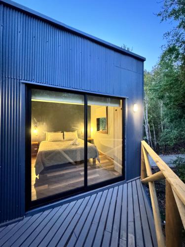 a house with a large glass window on a deck at Inspiramide Pucon in Pucón
