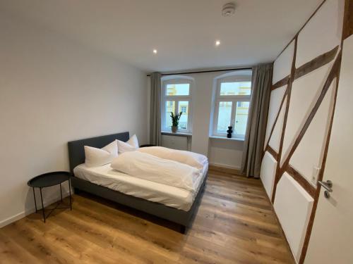 um quarto com uma cama com lençóis brancos e uma janela em Sanierter Altbau am Schloß em Marktbreit
