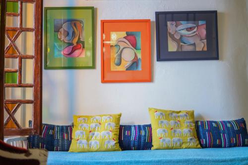 a room with a couch with paintings on the wall at Dar 91 Essaouira in Essaouira