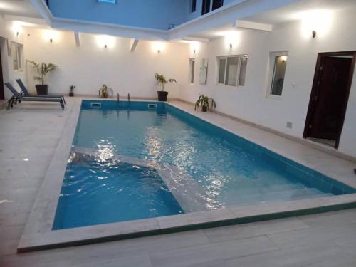 a swimming pool with blue water in a building at Résidence Marie France MENDY in Toubab Dialaw