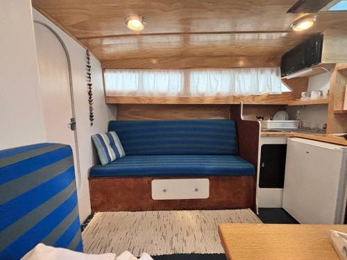 a living room with a blue couch in an rv at Wonderful boat for families and friends in Barcelona
