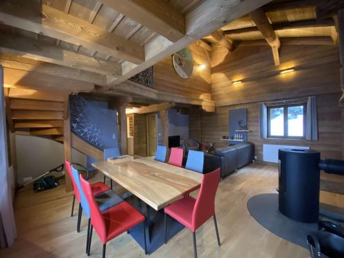 une salle à manger avec une table en bois et des chaises rouges dans l'établissement Chalet Charmant Rénové 2023 - 7 pers., 3 Chbres, Proche Hauteluce/Les Contamines - FR-1-342-309, à Hauteluce