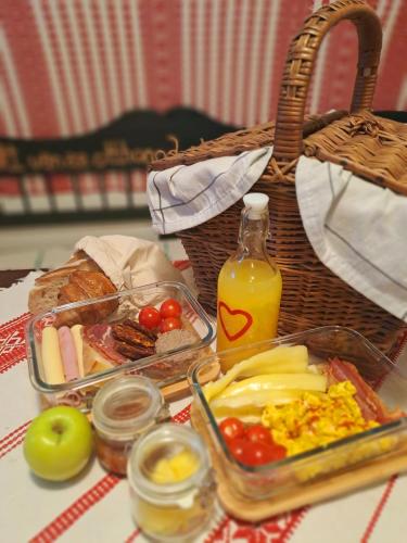 a table with a basket of food and a tray of fruit at Lassu Tanya Vendégház in Nagykőrös