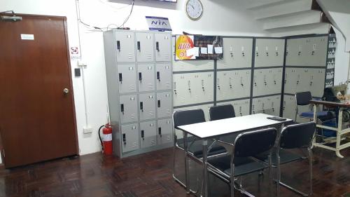 a room with lockers and a table and chairs at Punsuk in Khon Kaen
