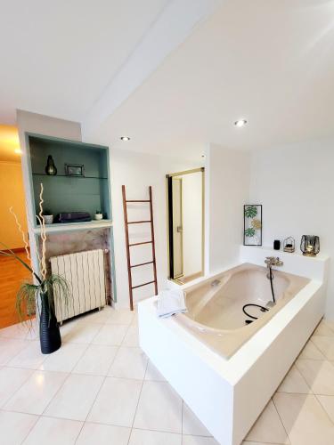 una gran bañera blanca en una habitación en Superbe Appartement Calme et Spacieux, en Graulhet