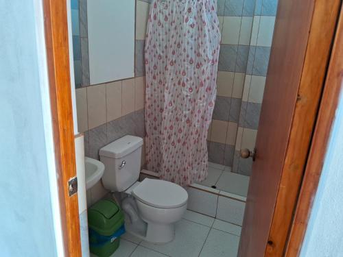 a bathroom with a toilet and a shower curtain at Dylan Beach in Zorritos