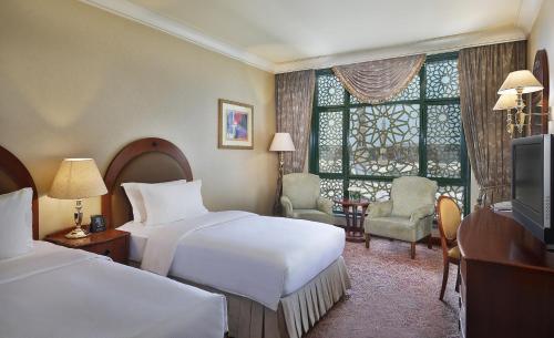 a hotel room with two beds and a window at Madinah Hilton Hotel in Al Madinah