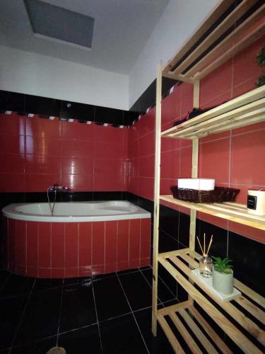 ein Badezimmer mit einer Badewanne und einer roten Wand in der Unterkunft Anna's house 