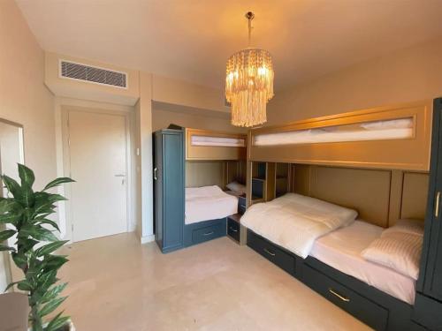 a bedroom with two bunk beds and a chandelier at Glamorous 2BR/ Free Beach & Pool Access @ Mangroovy, El Gouna in Hurghada