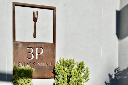 a sign with a fork on it next to some plants at Du Parc Hotel in Sauze dʼOulx