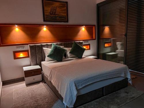 um quarto com uma cama grande e almofadas verdes em agafay villa em Marrakech