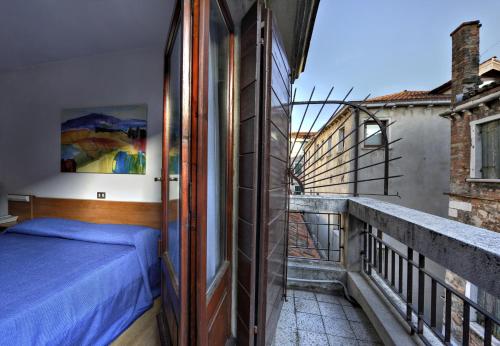 a bedroom with a bed on a balcony at Hotel Caprera in Venice