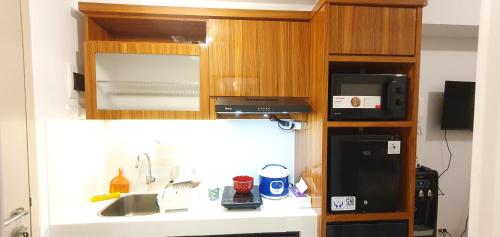 a kitchen with a sink and a microwave at Tokyo Riverside Apartment Studio at PIK2 in Gedong