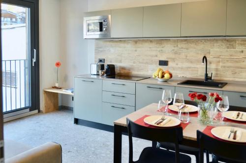 una cocina con una mesa con copas de vino. en Apartments Du Parc, en Sauze dʼOulx