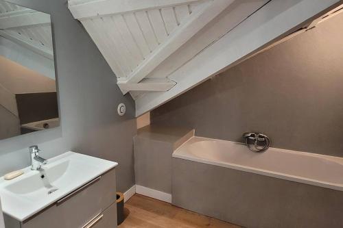 a bathroom with a sink and a bath tub at Au Bel Endormi in Saint-Paul