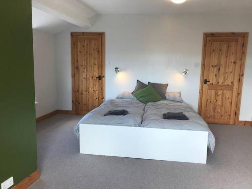 1 cama blanca grande en una habitación con 2 puertas en Hayfellside Cottage, Sleep 6,3 Bedrooms(1 ensuite), en Kendal
