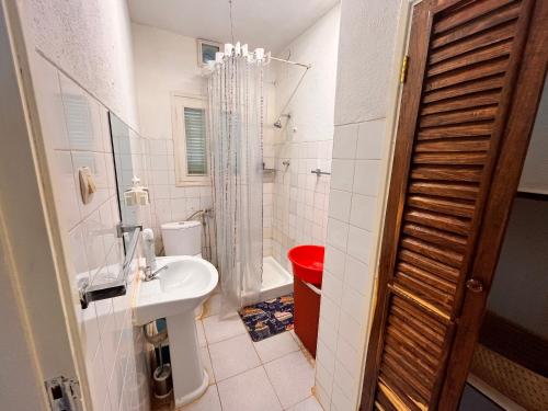 een kleine badkamer met een wastafel en een douche bij Sulas Beach House in Nampula