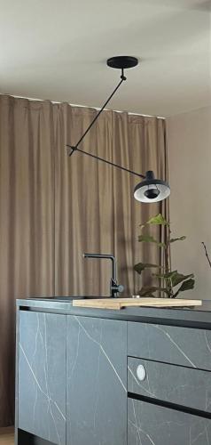 a black lamp sitting on top of a dresser at Modern Seafront Villa Steps from the Beach in Rogoznica