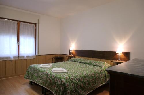 a bedroom with a bed with a green bedspread at Casa Ezio in Malesco