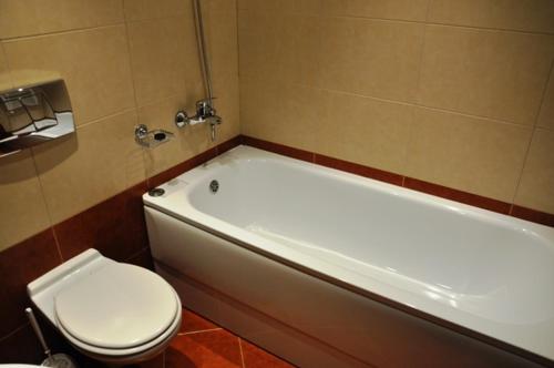 uma casa de banho com uma banheira branca e um WC. em PM Services Royal Plaza Apartments em Borovets