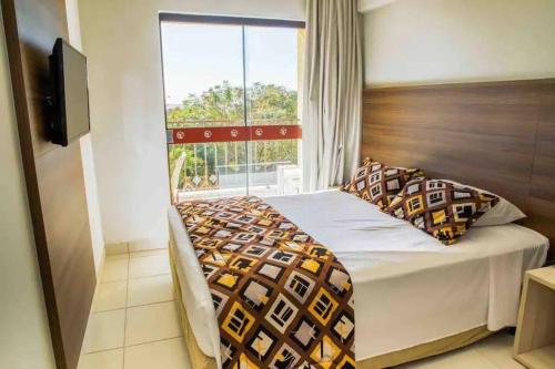 a bedroom with a bed with a large window at Quarto Barretos Country Resort in Barretos