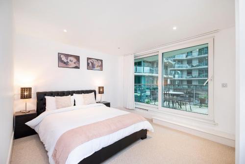a bedroom with a bed and a large window at Terraced riverview apartment in London
