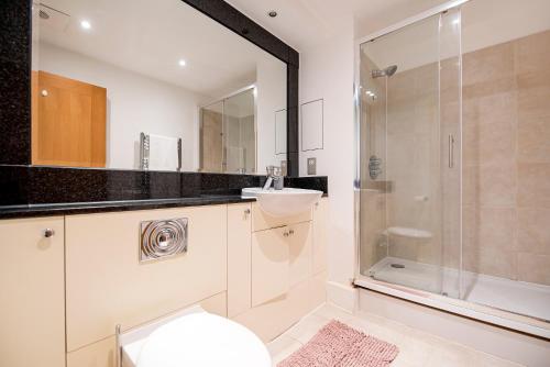 a bathroom with a toilet and a sink and a shower at Terraced riverview apartment in London