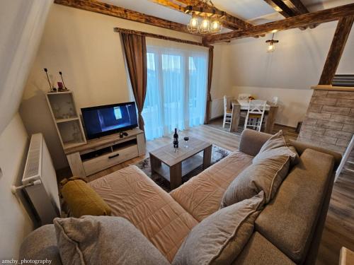 uma sala de estar com um sofá e uma televisão em Zlatar Eyes em Nova Varos