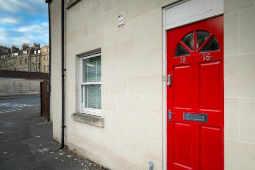 a red door on the side of a building at Bath Breaks Apartments in Bath