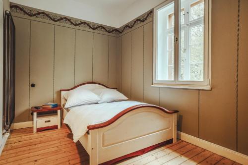 een kleine slaapkamer met een bed en een raam bij Museumsbahnhof Ahütte in Üxheim