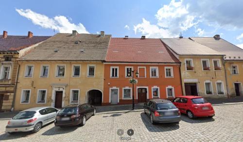 茲沃蒂斯托克的住宿－Klimatyczne Apartamenty Złoty Stok，停在大楼前的一组汽车