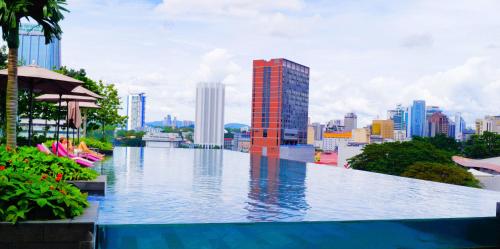 a large swimming pool with a city in the background at Opus Residences Kuala Lumpur by Luna in Kuala Lumpur