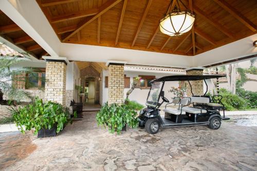 un carro de golf estacionado frente a una casa en Fontana di Rosa, African Style Villa Casa de Campo, en La Romana