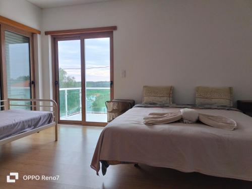 a bedroom with a bed and a large window at Residencial Monte Gordo Golf Rei Algarve in Monte Gordo