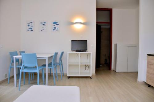 Zimmer mit einem Tisch, Stühlen und einem TV in der Unterkunft Seafront luminous flat in Bibione - Beahost in Bibione