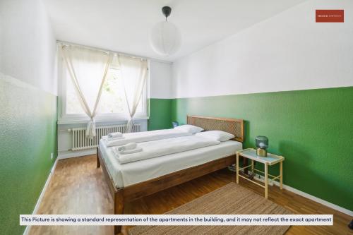 1 dormitorio con 2 camas y pared verde en Beautiful Boutique Apartment DRAHTZUG8 en Zúrich