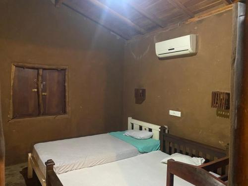 River End Cabana Udawalawe في اوداوالاوي: غرفة نوم بسريرين ومكيف