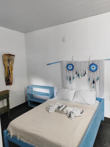 um quarto com uma cama com olhos azuis em Hospedaria Arte Sagrada em Canguaretama